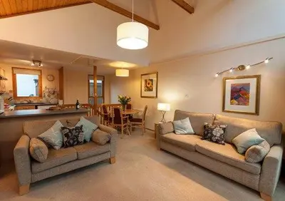 a living room with two couches and a kitchen at Keswick Bridge 13, within walking distance of Keswick town centre, strictly no pets in Keswick