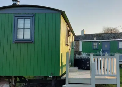 a green and green train car next to some buildings at Ryans Retreat, Bowness on Solway perfect for a break when walking Hadrians Wall with a hot tub in Bowness-on-Solway