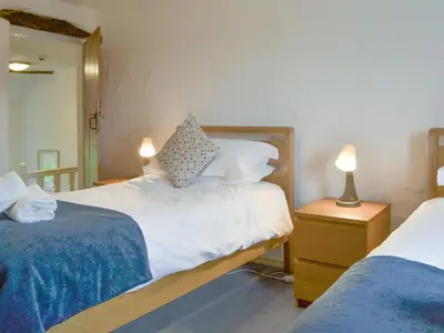 a bedroom with two beds and a mirror at The Retreat in Sunderland
