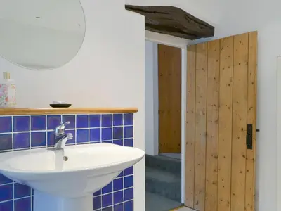 a bathroom with a white sink and blue tiles at The Retreat in Sunderland