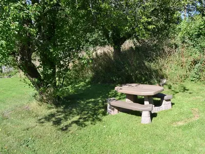 a picnic table in the grass next to a tree at The Retreat in Sunderland