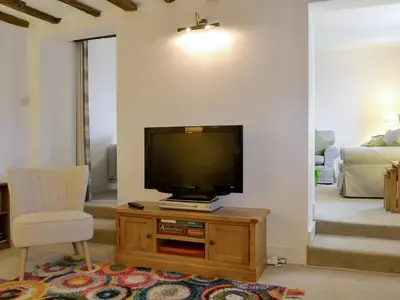 a living room with a flat screen tv on a wooden cabinet at The Retreat in Sunderland