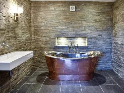 a bathroom with a copper tub and a sink and a bath tub at Ivy House in Dockray