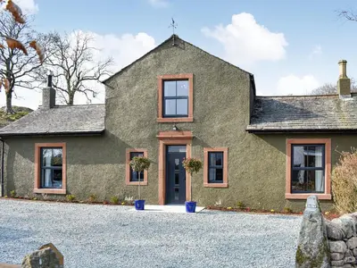 a house with a gravel driveway in front of it at Ivy House in Dockray