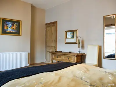 a bedroom with a bed and a dresser and a mirror at Long Rose in Keswick