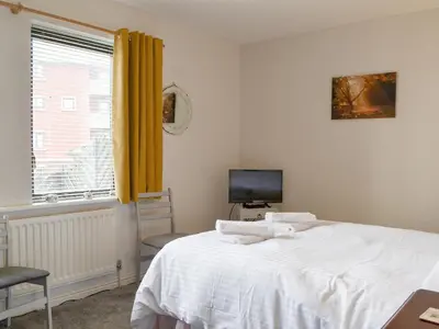 a bedroom with a bed and a tv and a window at Harbour Watch in Maryport