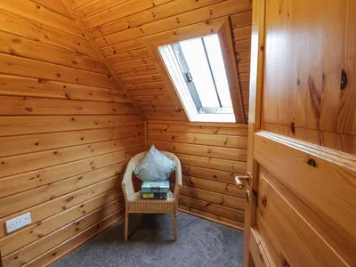 a small room with a chair in a log cabin at Moyle Lodge in Dalbeattie