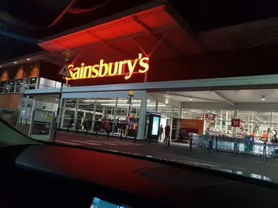 a sainsburys store with a neon sign on it at Luxury House Near City Center Hospital &Superstore in Carlisle