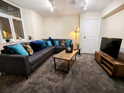 a living room with a couch and a television at Grove House in Egremont