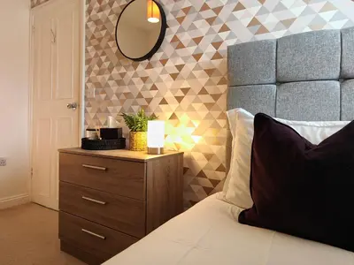 a bedroom with a bed and a mirror on a dresser at Grove House in Egremont