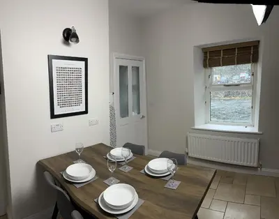 a dining room with a wooden table and a window at 1 The Croft in Cockermouth