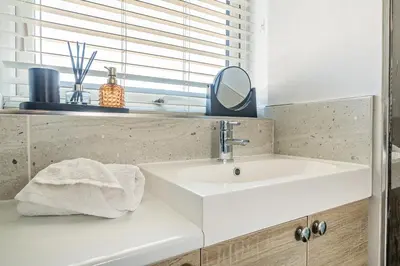 a bathroom with a white sink and a mirror at Normsy Place Seaside Serenity Breath Taking Views in St Bees