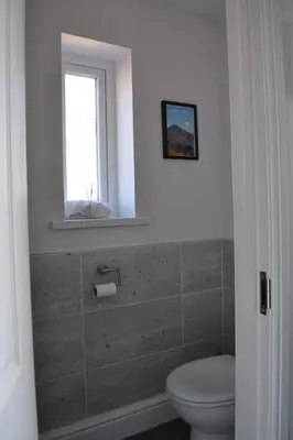 a bathroom with a toilet and a window at Normsy Place Seaside Serenity Breath Taking Views in St Bees