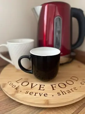 a wooden plate with a coffee cup on a table at Normsy Place Seaside Serenity Breath Taking Views in St Bees
