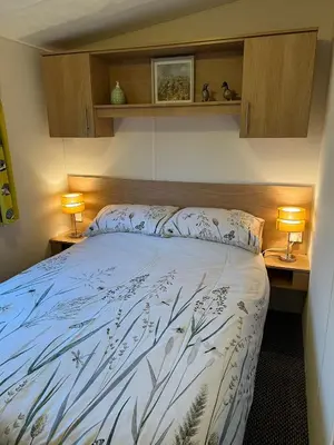 a bedroom with a bed with two lamps on both sides at Turnberry Holiday Home in Turnberry