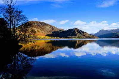 a view of a lake with mountains in the background at Teapot Cottage in Ennerdale - Hot tub Pizza Oven Log Burner in Cleator