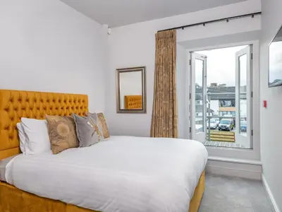 a bedroom with a large bed and a window at Apartment 2 Blencathra in Keswick