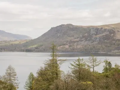 a view of a lake with trees and mountains at Apartment 3 Helvellyn in Keswick