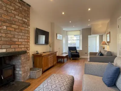 a living room with a couch and a fireplace at Wordsworth House HOT TUB HIRE AVAILABLE in Keswick
