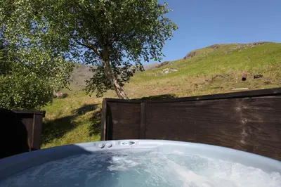 a bath tub with a tree and a hill at The Mountain Cottages - Millrace in Coniston