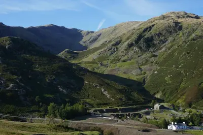 a winding mountain road through a valley in the mountains at The Mountain Cottages - Millrace in Coniston
