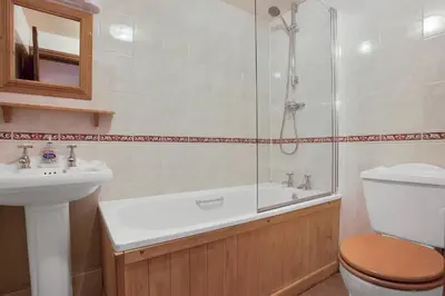 a bathroom with a shower and a toilet and a sink at The Mountain Cottages - Millrace in Coniston