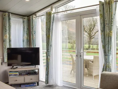 a living room with a tv and a sliding glass door at Dodd - Uk42499 in Bassenthwaite