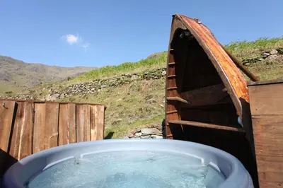 a bath tub in a boat with water in it at The Mountain Cottages - Pelton Wheel in Coniston