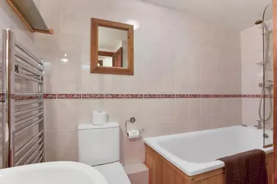 a bathroom with a toilet and a sink and a mirror at The Mountain Cottages - Pelton Wheel in Coniston