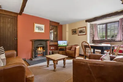 a living room with a fireplace and a tv at The Mountain Cottages - Pelton Wheel in Coniston