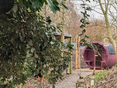 a red object is sitting next to a tree at Bird House - Sleep with the Owls! in Carlisle