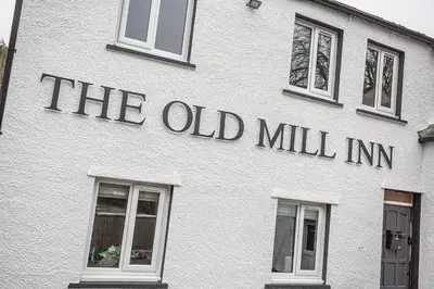 a white building with the old mill inn written on it at The Old Mill Inn in Dearham