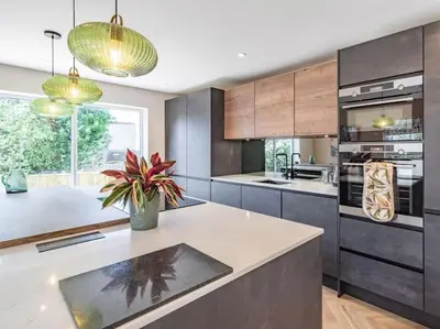 a kitchen with a large island with a potted plant at Northdene - 5 star Lake District Cottage in Cockermouth