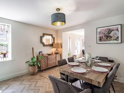 a dining room with a wooden table and chairs at Northdene - 5 star Lake District Cottage in Cockermouth