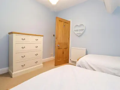 a bedroom with a bed and a dresser and a heart mirror at Blencathra in Keswick