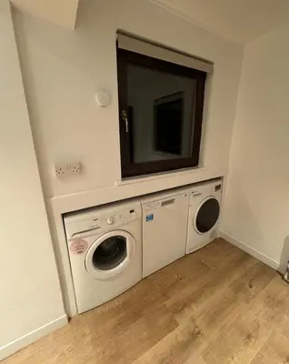 a laundry room with two washing machines and a mirror at 4 Bed House - Sleeps 9 - HotTub - Parking in Beattock