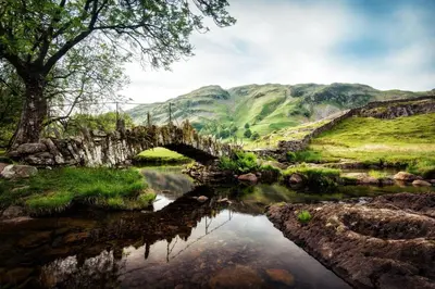 an old stone bridge over a river in a valley at Herdwick Place Langdale Valley in Great Langdale