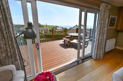a living room with a deck with a sliding glass door at Cedar Lodge in Portpatrick