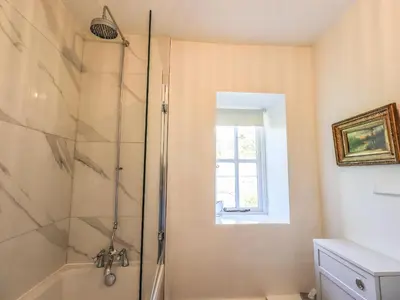 a bathroom with a shower with a glass at St Giles in Ambleside