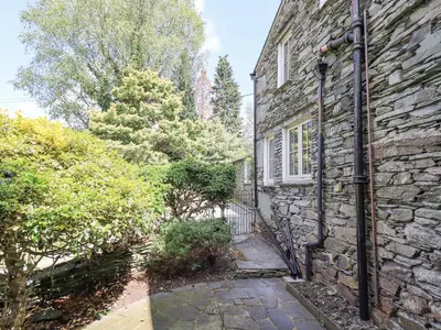 a stone house with a pathway leading into a yard at St Giles in Ambleside
