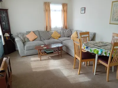 a living room with a couch and a table and chairs at Glen Dhoo Country Cottages - Meadowview Bungalow in Onchan