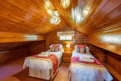 a bedroom with two beds in a log cabin at Lady Galloway 27 with Hot Tub in Newton Stewart