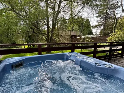 a blue hot tub in a yard next to a fence at Lady Galloway 27 with Hot Tub in Newton Stewart
