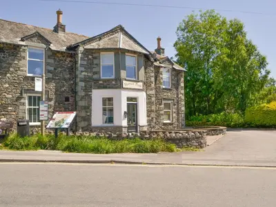 an old stone house on the side of a street at 1 Harney Peak in Portinscale