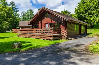 a log cabin with a driveway in front of it at Lady Galloway 30 with Hot Tub in Newton Stewart