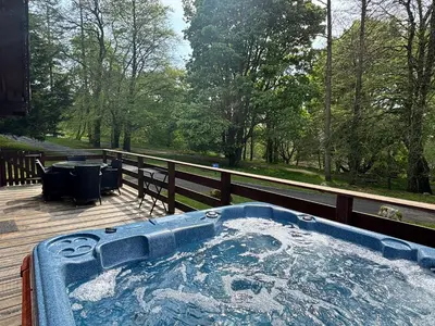 a jacuzzi tub on the deck of a house at Lady Galloway 30 with Hot Tub in Newton Stewart