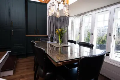 a dining room with a long table and chairs at Greta Howe in Keswick