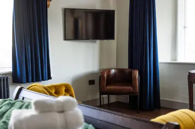 a living room with a television and a chair at Greta Howe in Keswick