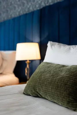 a bed with a green pillow and a lamp at Greta Howe in Keswick