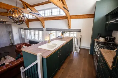 a kitchen with green cabinets and a sink at Greta Howe in Keswick